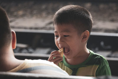 Portrait of boy eating outdoors