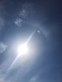 Low angle view of bright sun in sky