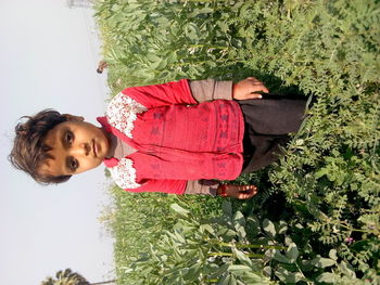 Portrait of woman standing against plants