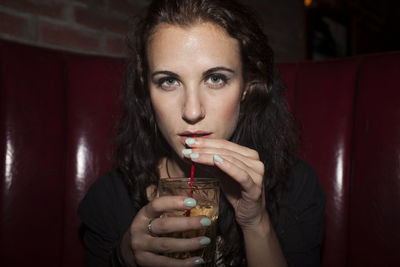 Portrait of young woman drinking glass