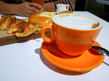 Close-up of man holding coffee cup on table
