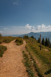 Dirt road along landscape and against sky