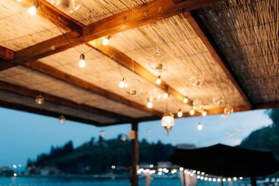 Low angle view of illuminated light bulbs hanging from roof