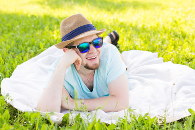 Man wearing sunglasses lying down on field