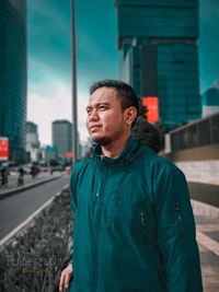 Mid adult man standing against city in background
