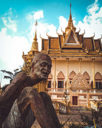 Low angle view of statues on building against sky