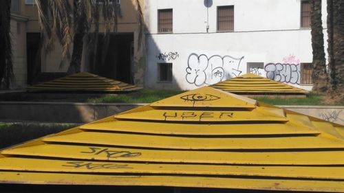 Close-up of yellow text on brick wall