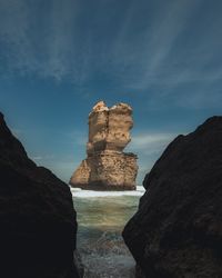 Rock formations by sea against sky