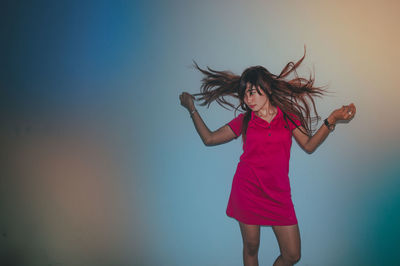 Full length of a young woman standing against the sky