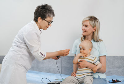 Female friends using digital tablet while sitting at clinic