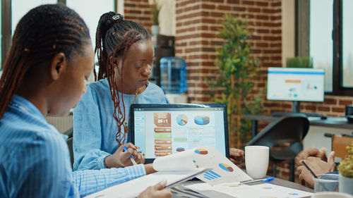 Side view of colleagues working at office