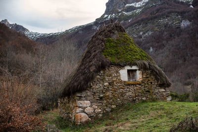 Old house on mountain against sky