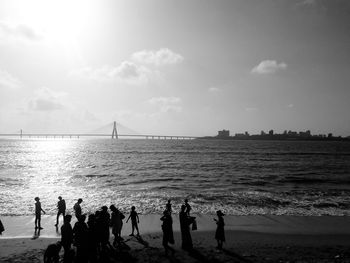 People on beach against sky