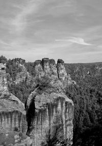 Rock formations on mountain against cloudy sky