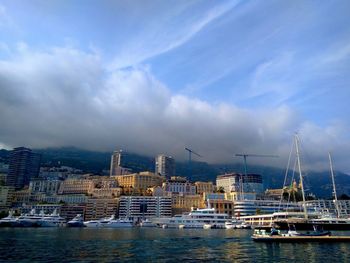 Boats moored on sea against buildings in city