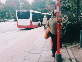 Rear view of woman standing on road