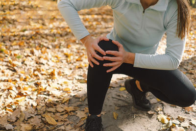 Low section of woman tying shoelace