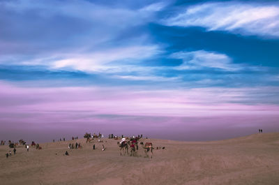 Panoramic view of people on landscape against sky