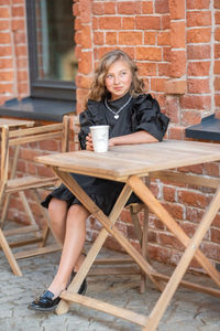 Portrait of young woman sitting on coffee