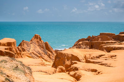 Scenic view of rocks on beach against sky