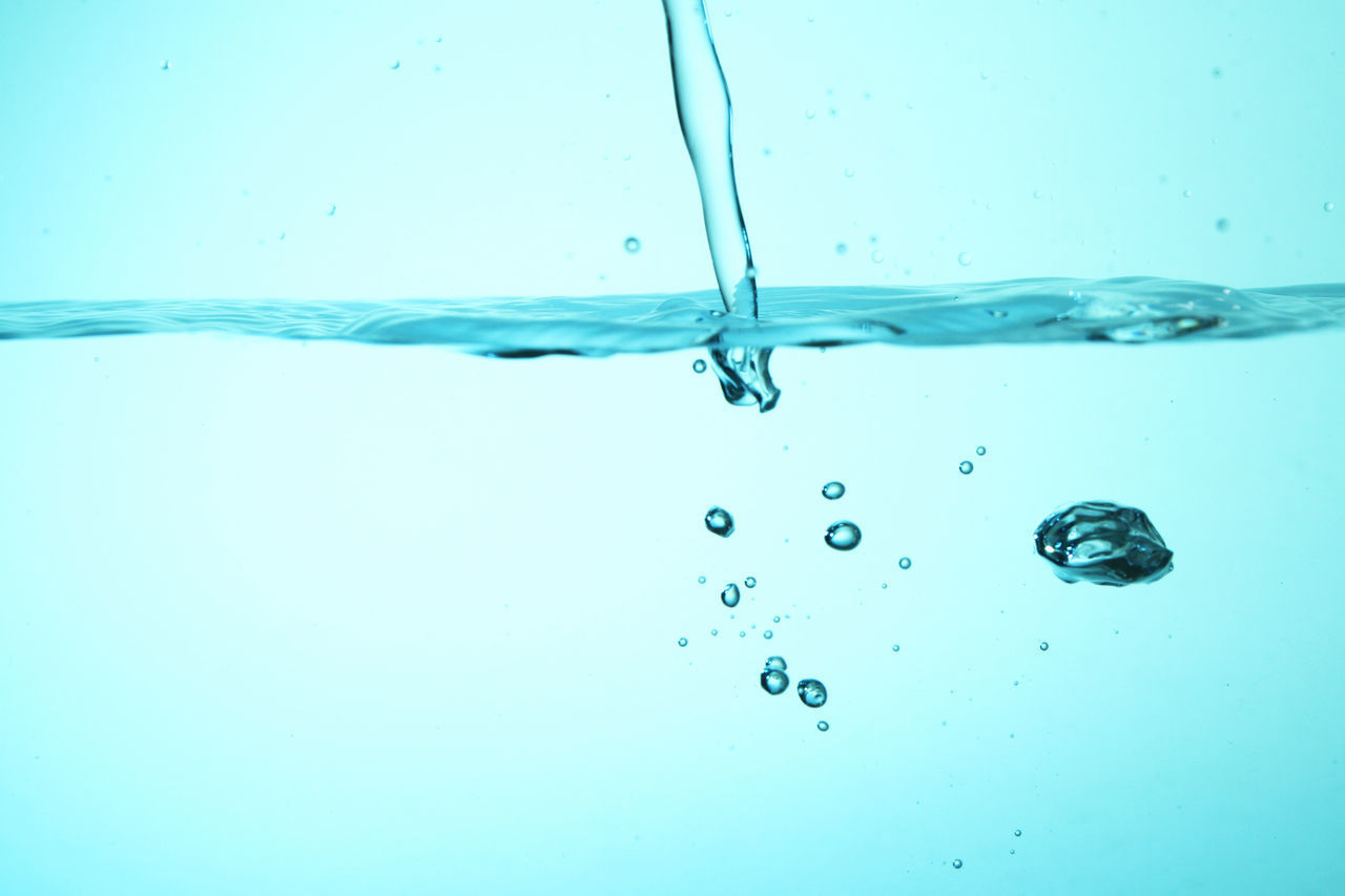 CLOSE-UP OF WATER DROPS ON BLUE SURFACE