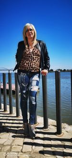 Portrait of smiling woman standing against water