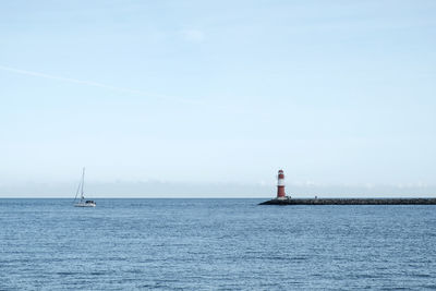 View of lighthouse in calm sea against sky