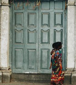 Rear view of woman standing against wall