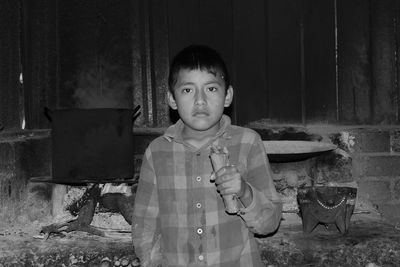 Portrait of boy standing against wall