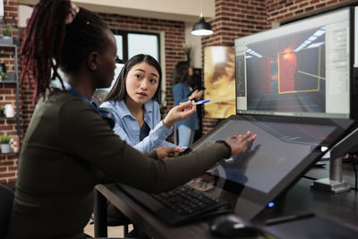 Side view of businesswoman using computer at office