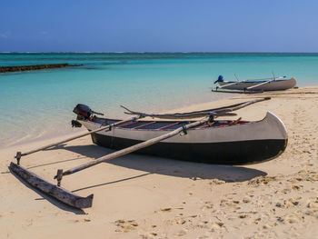 Fishing boat on beach against sky