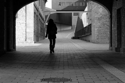 Rear view of man walking in corridor