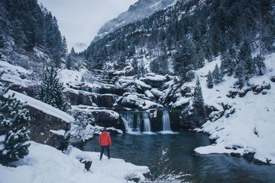 Man standing against waterfall during winter