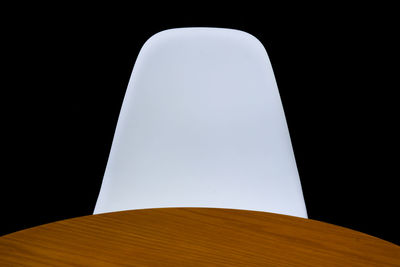 Low angle view of illuminated lamp against black background