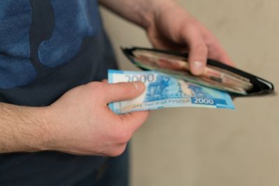 Midsection of man removing paper currency from wallet