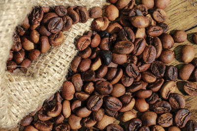 Close-up of roasted coffee beans by jute on table