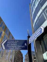 Low angle view of information sign against buildings in city