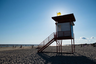 G4s lifeguard tower with yellow flag indicating swimming is dangerous for poor swimmers.