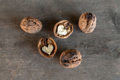 Walnuts with heart on rustic wooden background, top view. healthy food.