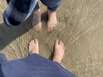 Low section of people standing on beach