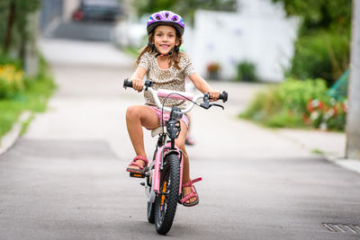 Cute girl riding bicycle on road