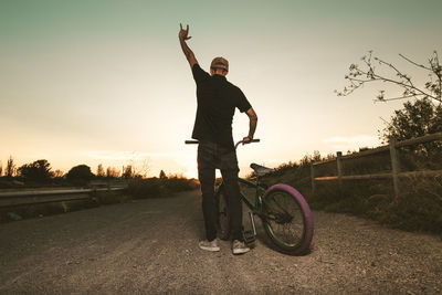 Man riding bicycle at sunset