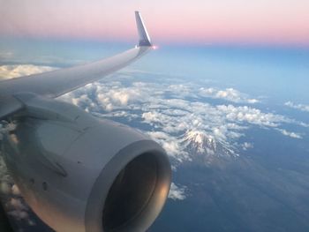 Aerial view of airplane wing over clouds