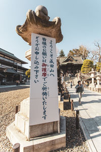 Information sign against sky in city