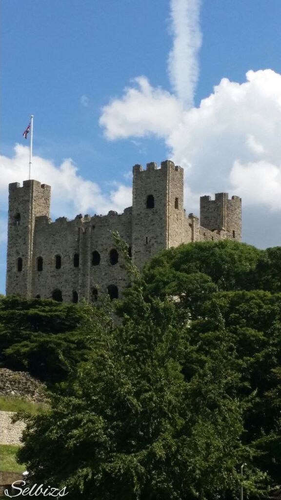 architecture, built structure, building exterior, sky, cloud - sky, low angle view, tree, history, cloud, tower, growth, day, green color, castle, old, plant, no people, outdoors, the past, stone wall