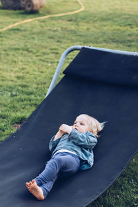 Full length of baby girl relaxing on folding chair at lawn