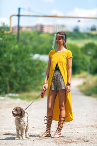 Full length of woman with dog standing outdoors