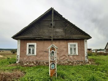 Abandoned house on field against sky