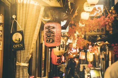 Illuminated lanterns hanging at store