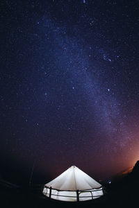 Low angle view of illuminated tent against sky at night